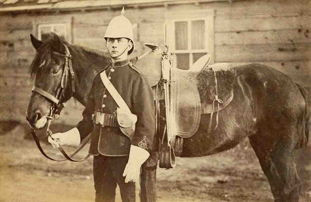 The Royal Canadian Mounted Police Museum provided the (above) photograph of the North-West Mounted Police (NWMP) constable wearing the circa 1883 Mills/Orndorff web belt. The belt appears to be worn upside down with the grommet holes, normally used by Americans to hang a holster or bayonet, on the topside of the belt instead of on the bottom. The NWMP constable is wearing the belt with the .476 revolver loops on the right side, with the revolver holster on the left in a cross-draw arrangement. Also, notice the 1876 Winchester slung over and tied down to the saddle pommel.